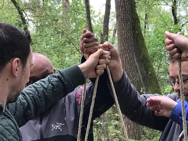 hands holding ropes to balance a platform